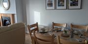 Dining table with 3 photos of Causeway Coast behind it