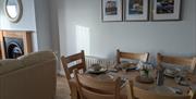 Dining table with 3 photos of Causeway Coast behind it