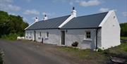 A traditional white country cottage at the roadside.