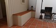 A small bench beside a small cottage fireplace.