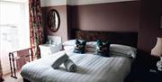 large superking bed in a pink room overlooking courtyard
