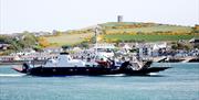 Photo on a bright day of the Strangford Ferry with Windmill Hill and Portaferry in the backdrop