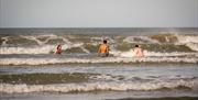 Group in the crashing waves enjoying the Mussenden Unwind experience