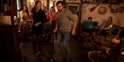 Man joining in with Irish dancing as part of the Ceili & Craic experience at The Ponderosa.