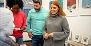 A group of people admiring the art in Frankie Creith's studio