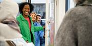 A group is shown entering Frankie Creith's art gallery and creative workshop