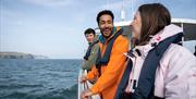 Group on a boat wearing lifejackets as part of a scuba diving experience with Aquaholics