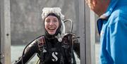 Girl on a boat in scuba diving gear as part of a scuba diving experience with Aquaholics