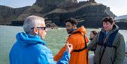 Guide/skipper of the boat talking to a group enjoying the Giant Shipwrecks of the North Coast experience