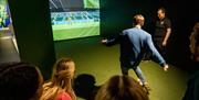 Group enjoying an interactive virtual football session as part of a behind the scenes guided tour of Windsor Park with the Irish Football Association