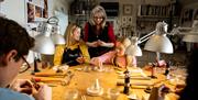 Instructor watching over the group as they make jewellery as part of the workshop with Gobbins Craft in Islandmagee