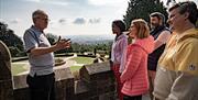 Guide Rodney talking to the group with the gardens of Belfast Castle in the background as part of the Cavehill Walking Tour with Experience and Explor