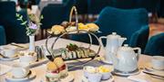 Afternoon tea in the Ross Park Hotel served on silver stand with white crockery and tablecloth