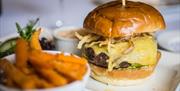 Cheeseburger with chips served on white plate