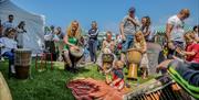 Children enjoying a drumming lesson on the grass