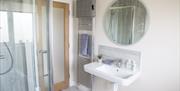 Bathroom with a walk-in shower, sink and towel rack.