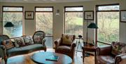 reading room with large viewing windows overlooking countryside views and river
