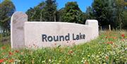 A wall with wildflowers displaying the name Round Lake