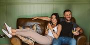 Models relaxing on sofa located in the lounge area of the Shepherd's Hut