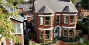 An aerial view of Ravenhill House, redbrick townhouse, with trees in the foreground.