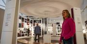 A lady in a pink jumper enjoys learning about Seamus Heaney through the displays