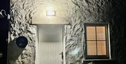 Atmospheric night-time  shot of the side of The Barn with the glowing light casting shadows