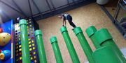 An image of a person standing on top of the green pillars obstacle known as the Stairway to Heaven