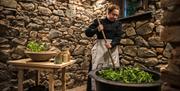 Image of a lady stirring the pot of nettle soup