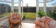 Giant's Causeway Sunroom with Chairs and an open door leading to the back garden.