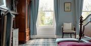 bedroom setting with wardrobe, large windows with garden view and luxury tartan carpet