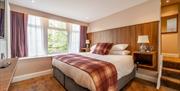A double bedroom  with a large window and a TV.