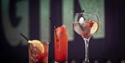 3 different glasses of cocktails -   small tumbler, tall glass and a goblet glass.