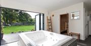 A sauna and jacuzzi area with large patio doors opened to a large back garden.