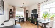 Dining area with four two-seater tables, a fireplace, a TV and a grandfather clock.