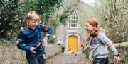 Children enjoying the autumn leaves in the museum grounds