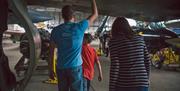 Family walking under the wing of an aircraft in bunker