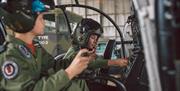 Children in cockpit of helicopter with helmets on and using controls