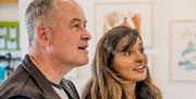 Man and woman looking at Quentin Blake artwork in a gallery