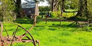 Vintage farm machinery in close up with traditional cottage in the background