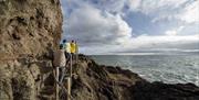 Group ascends steps built into the cliff face of The Gobbins