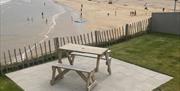 lower patio with picnic table looking over the beach