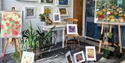 Window display in Midtown Makers of paintings of flowers by artist Amy Ashe.