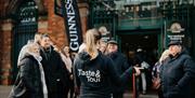 Group of guests listening to Taste & Tour tour guide outside of St George's Market on Belfast Food Tour