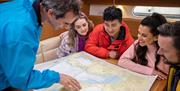 Group review a map of the local area on board the boat