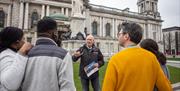 A group listening to a tour guide outside Belfast city hall.