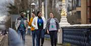 A tour group walking on the Queen's bridge in Belfast.