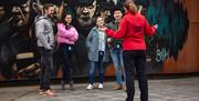 Group stand beside mural of Titanic workers in Belfast