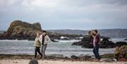 Group take a walk along the beach as part of the Giant Tours experience