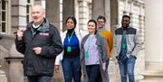 A group following a tour guide around the city hall.