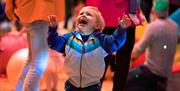 Images of smiling children and adults, bright colours, movement